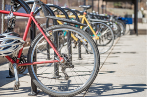 A row of bikes locked to a bike rack.