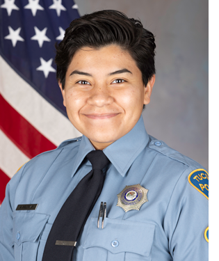 Department photo of a TPD CSO in uniform in front of an American flag.
