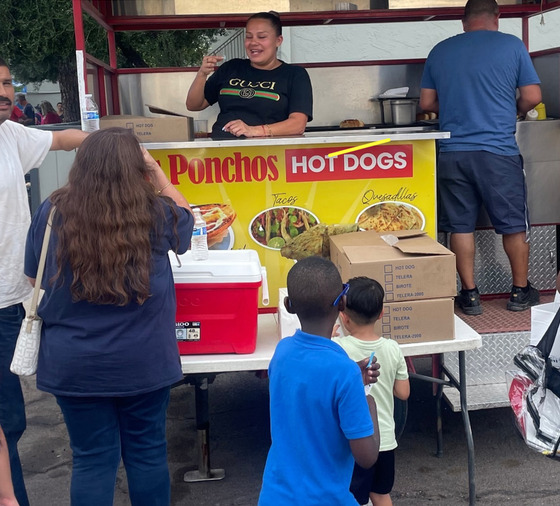 Photo of los Pochos Hotdogs being served to kids.