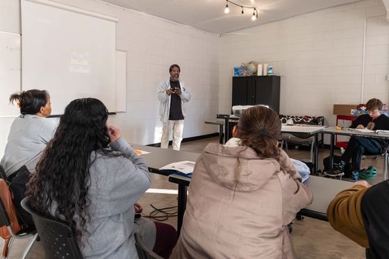 Photo of Hassan speaking in front of people