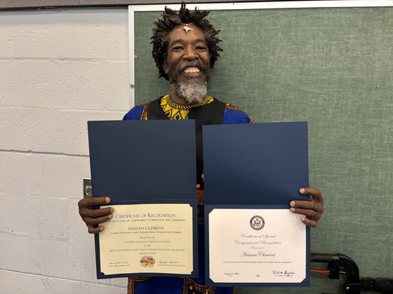 Photo of Hassan Clement with his two Award Certificates.