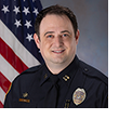 TPD captain in uniform in front of an American flag.
