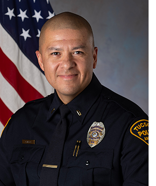 TPD officer in uniform in front of an American flag.