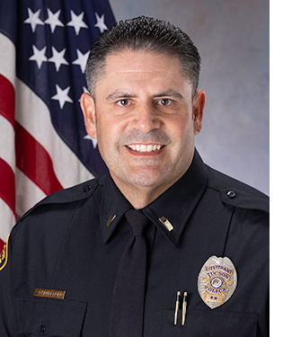 TPD officer in uniform in front of an American flag.