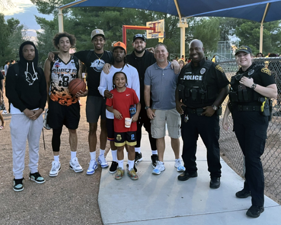Group at outside play area, youth, TPD officers, and Council Member Paul Cunningham.