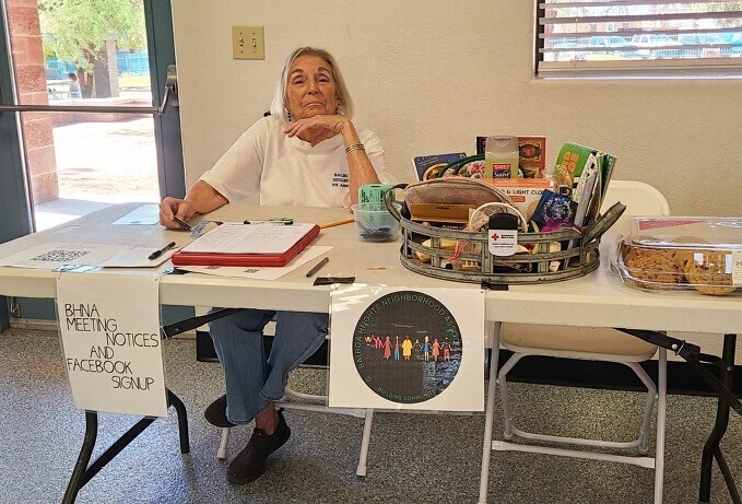 Photo of  Hilary Madrid, longest serving board member of Balboa Heights NA, holding down the table.