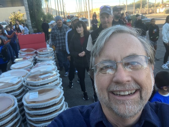 Photo of Vice Mayor Kevin Dahl helping assemble 750 Thanksgiving meals along with Tucson Firefighters, their families, cadets, and others.