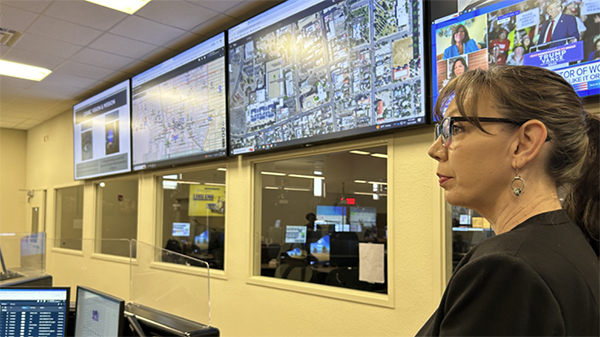 Councilwoman Nikki Lee checks out a room with multiple computer monitors and screens showing live feeds and maps.