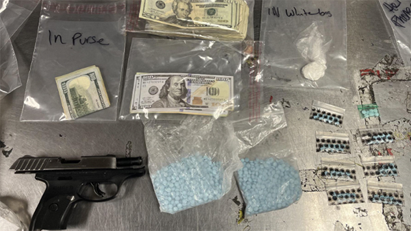 Evidence in plastic baggies includes money and pills, as well as a handgun.