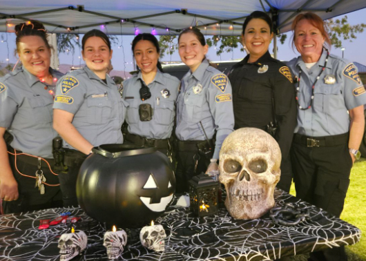 ODE CSOs and Officers stand at a table with spooky skull displays.