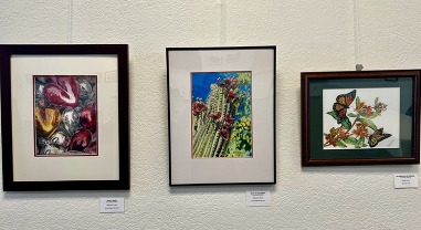 Three paintings are on display in the community room
