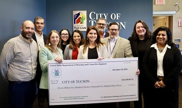 HCD and City of Tucson staff posing with large check from HUD
