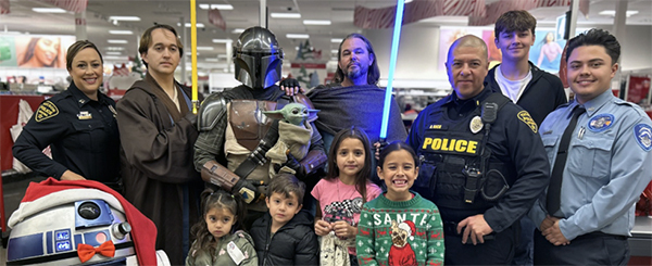 TPD members in uniform and kids pose for a group photo in Target with Star Wars heroes.