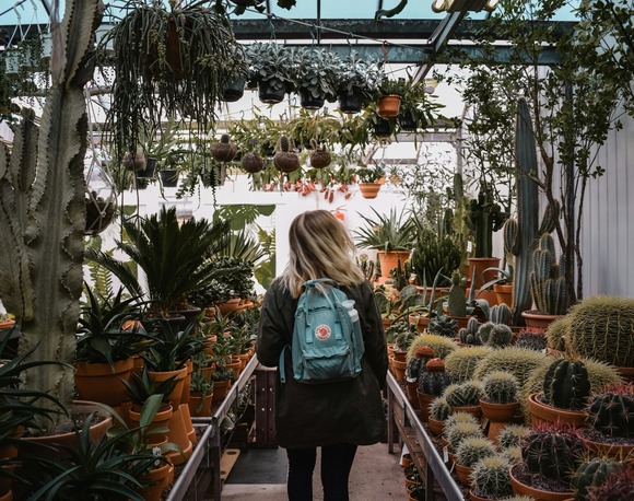 young woman walking through arid plant greenhouse