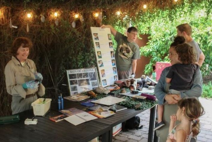 Picture of staff answering questions to family about the posters they are sharing
