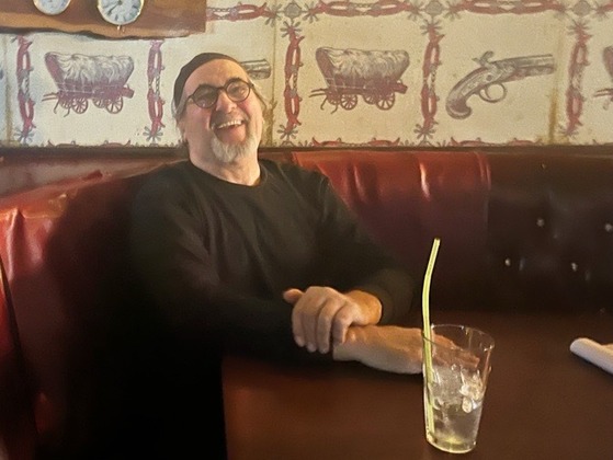 Photo of Richard Snyder, one of the owners of Danny’s Baboquivari Lounge, with the now famous wallpaper behind him.