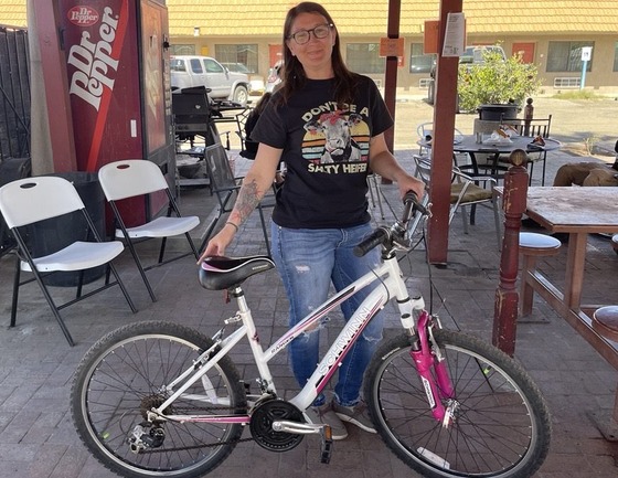 photo of Wildcat Inn resident, Taygan, pictured with her bike just after her brakes were fixed.