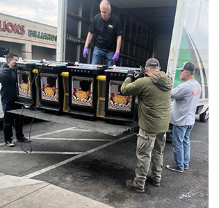 Men load slot machines onto the back of a commercial truck.