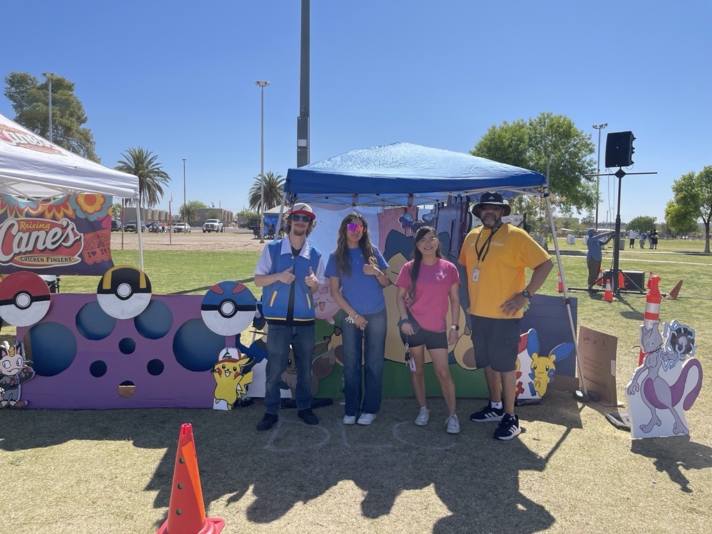 Photo of Donna Liggins Center staff, Michael, Nat, Liz, and Jeff, in front of their Pokémon booth.