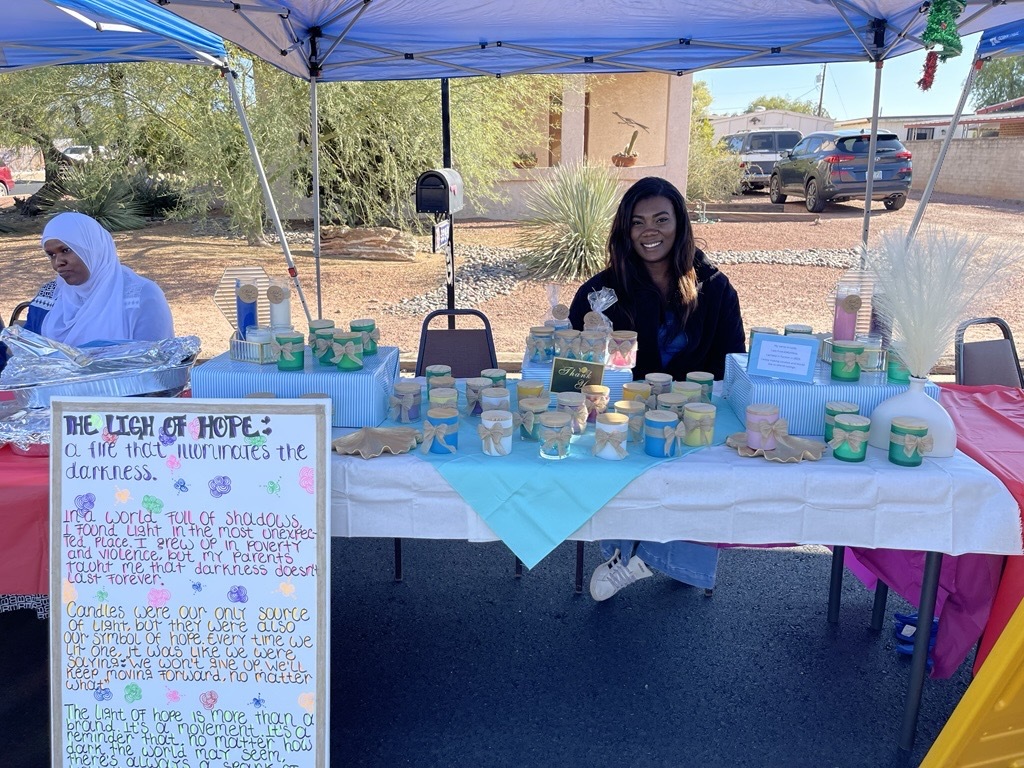 photo of Leidy at her Light of Hope booth selling candles.
