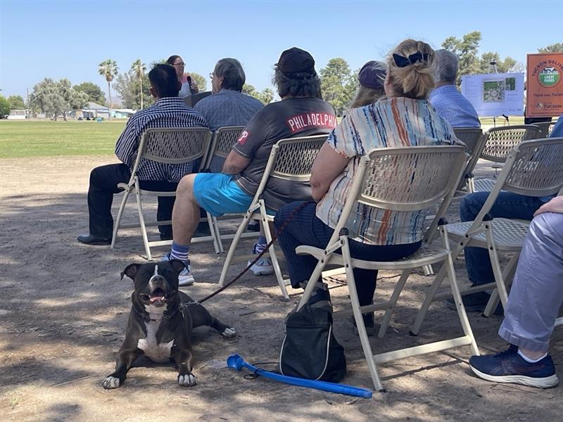 Photo of Gizmo with his owner Leslie listening to groundbreaking remarks.