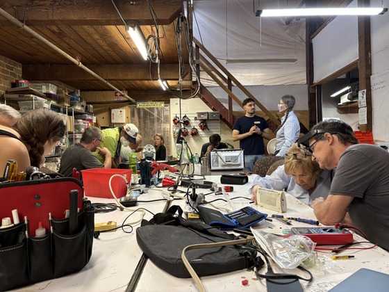 Photo of a group of people repairing devices at the Tucson Repair cafe.