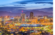 Nightscape of downtown Tucson with mountains in the background.