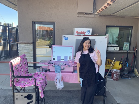 Photo of Karen Altamirano, owner of KM Paint, by her table ready to paint faces.