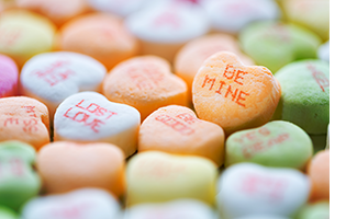 Candy hearts with writing. One says, "Be Mine." Another says, "Lost Love."