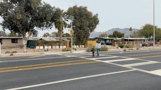GIF of a mother and child crossing the street.