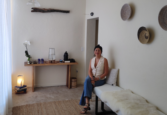 Photo of Adina Diaz, sitting, at Guided Flame Spa & Wellness.