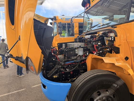 Photo of A close up look at the bus's battery underneath the hood. 