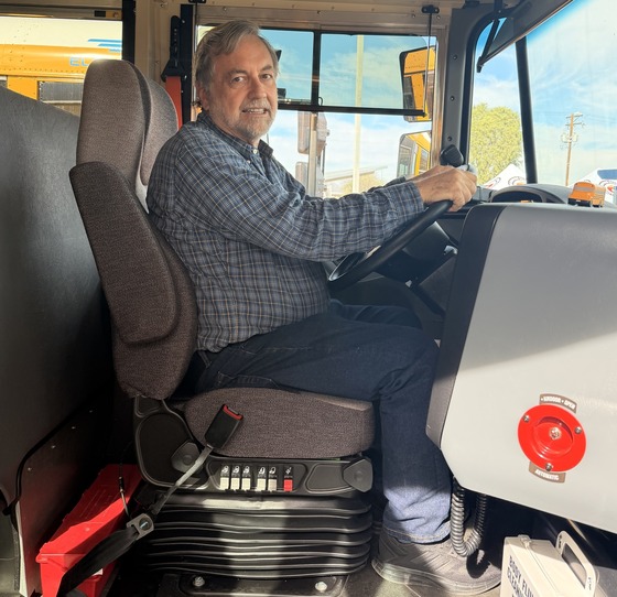 Photo of Council Member Dahl sitting at the wheel of an electric bus.