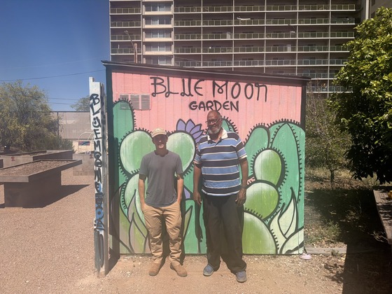 Sammy Kaplan and Mike Thomas in front of the Blue Moon mural painted on the garden shed. 