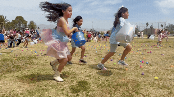 GIF of Kids running to collect eggs during the egg hunt.