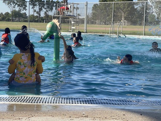 Kids swimming and enjoying the water cannon at Jacobs Pool.