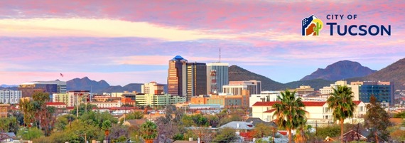 Outdoor aerial view of Tucson, Arizona under a colorful sky with the City of Tucson logo overlaid in the top right corner.