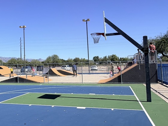 The refurbished basketball court alongside the new skate park, where families are enjoying skating and practicing their tricks. 