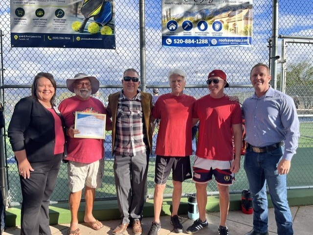 Paul Cunningham presents a certificate to a group at the Udall Pickleball Courts