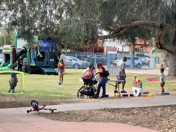 Families playing lawn games and soccer with the jumping castle in the background