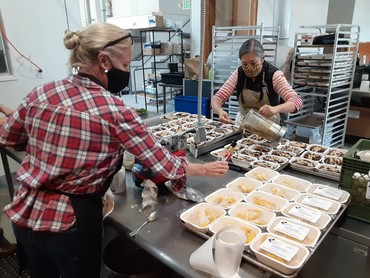 Berkeley Food Network staff prepare individual portions of nutritious meals from recovered food. 
