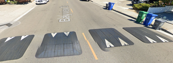 Image of rubberized speed cushions on a street