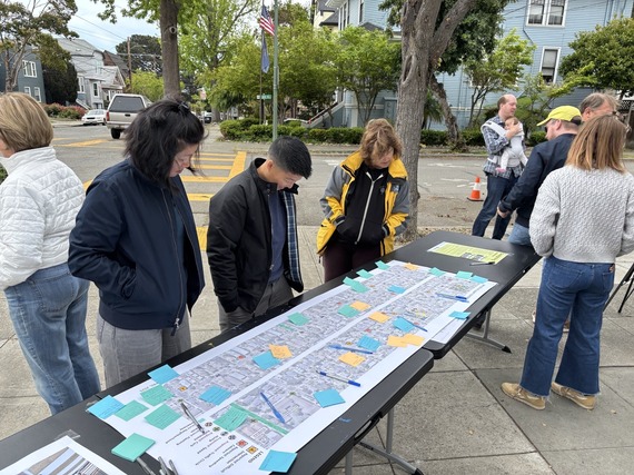 Photo of people looking at a roll plot, at San Jose 4/19 Pop up event