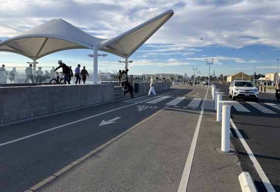 Photo showing Seaplane Lagoon ferry terminal with people walking, biking, and driving