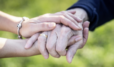 Pair of young hands holding an older person's hands