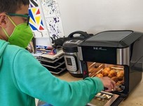 Youth cooking potatoes in an air fryer