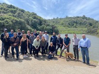 Group of multicultural adults posing for a picture in front of a lake
