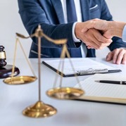 Two people shaking hands and a scale of justice 