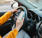 Person looking at their phone while sitting in a car