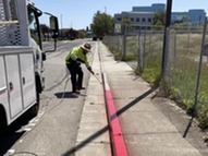 Staff painting a red curb
